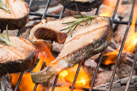 Laužas su ant grotelių kepama žuvimi