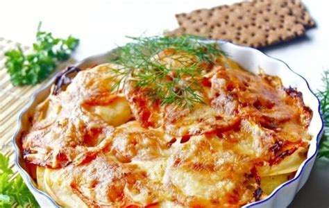 Sluoksniuota žuvies užkepėlė su bulvėmis ir svogūnais iš arti