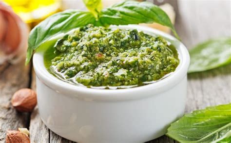 Šviežias pesto padažas dubenėlyje su bazilikais ir riešutais
