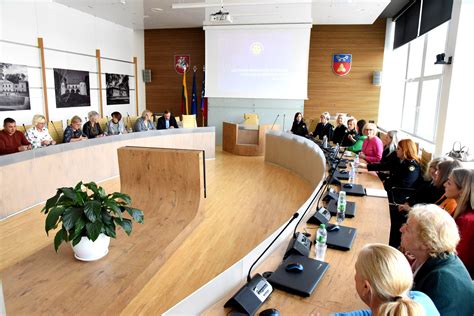 Probacijos tarnybos atstovai su senole dalinantys keksiukus ir bendraujantys