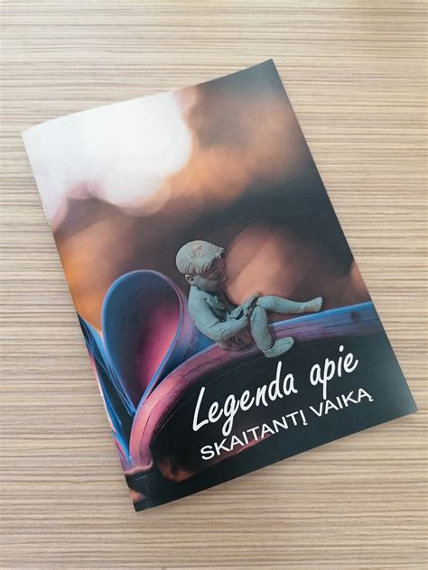 Vaikas, skaitantis knygą po medžiu