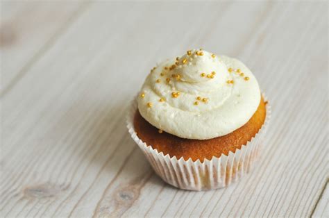 Bananinių keksiukų su karamelės įdaru ir grietinėlės kepurėmis iliustracija