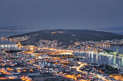 Trogiras naktį su apšviestomis gatvelėmis