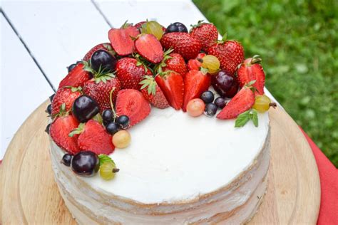 Gražiai dekoruotas vanilinis tortas su mėlynėmis ir kremo papuošimais