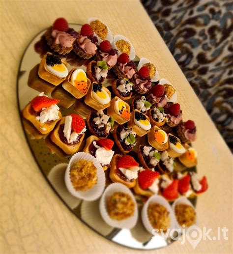 Stalas pilnas įvairių vieno kąsnio užkandžių