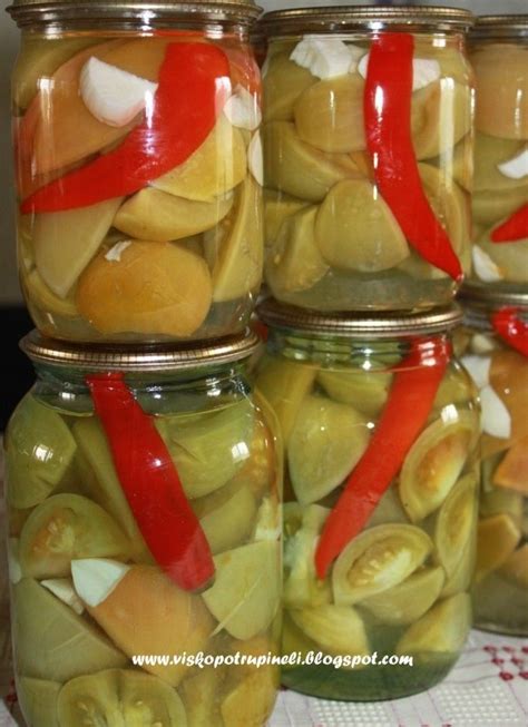 Stiklainis marinuotų žalių pomidorų su morkomis ir česnaku