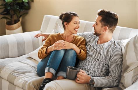 Du žmonės, moteris ir vyras, šypsodamiesi bendrauja kavinėje