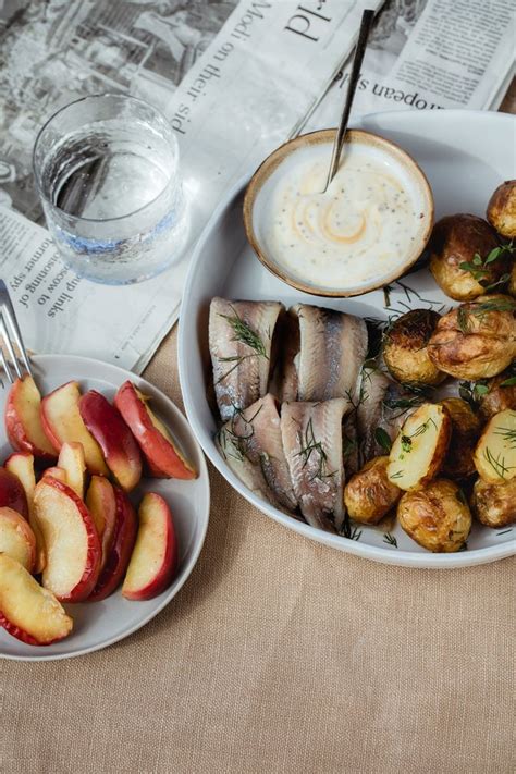 Tradicinis Surströmming patiekimas su bulvėmis ir tunnbröd