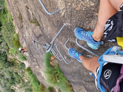 Žmonės, besinaudojantys Via Ferrata įranga, lipantys uolomis