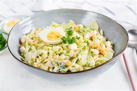 Salotos su kukurūzais, pomidorais, alyvuogėmis ir kiaušiniu