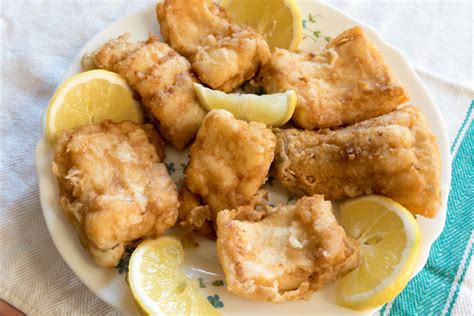 Kepta žuvis, papuošta citrinos griežinėliais ir šviežiais krapais