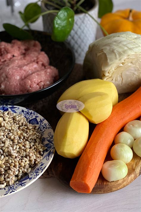 Perlinių kruopų, bulvių ir morkų ingredientų rinkinys ant medinio stalo