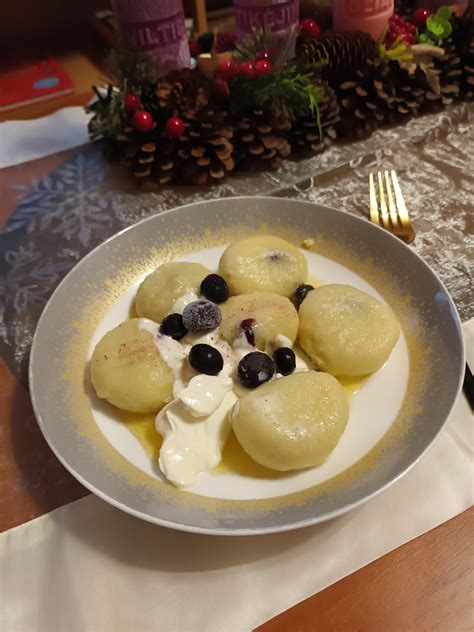 Patiekti varškės virtinukai su grietine, rudu sviestu ir uogiene