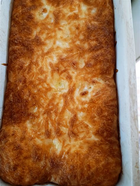 Paruoštas patiekalas su auksine sūrio plutele kepimo inde