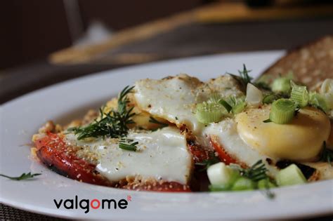 Auksiniai kiaušiniai su pomidorais ir feta, papuošti šviežiais žalumynais