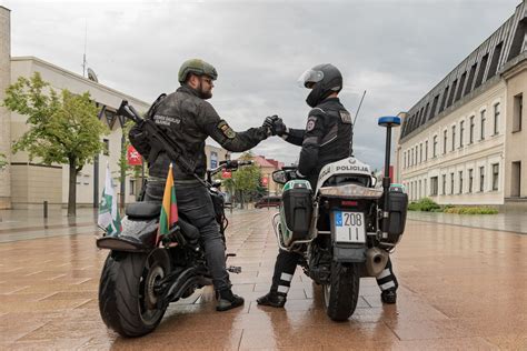 Jaunuoliai, stovintys ant motociklo ir besibučiuojantys prieplaukoje saulei leidžiantis
