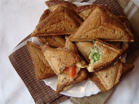 Gražiai sudėlioti trikampiai sumuštiniai