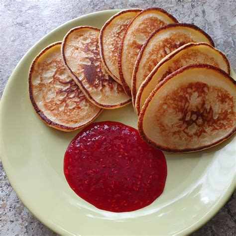 Paruošti veganiški bananiniai blyneliai su uogomis ir sirupu
