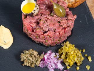 estetiškai patiektas jautienos tartaras su žalumynais ir duona
