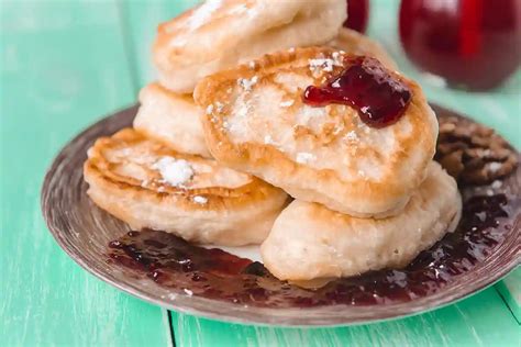 Ažūriniai mieliniai blynai ant lėkštės su uogiene