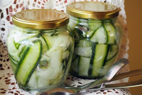 Nuotrauka su paruoštu stiklainiu marinuotų cukinijų ir agurkų