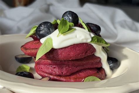 Indelis su jogurtu ir uogomis šalia kukurūzų miltų blynų