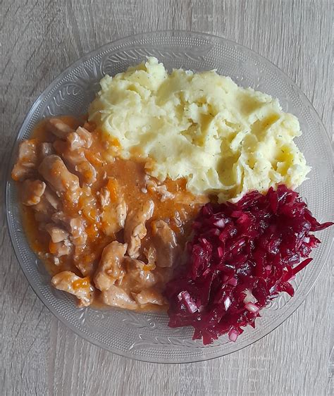 Kiaulienos guliašas lėkštėje su bulvių koše ir salotomis