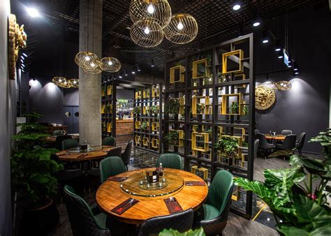 Erdvus kinų restorano interjeras su tradiciniais raižiniais ir staliukais