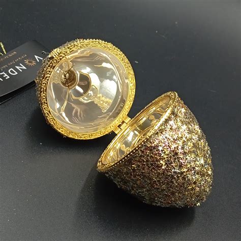 Stilizuotas auksinis kiaušinis su smurfų elementais