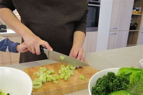 Studentai mokosi gaminti maistą modernioje virtuvėje