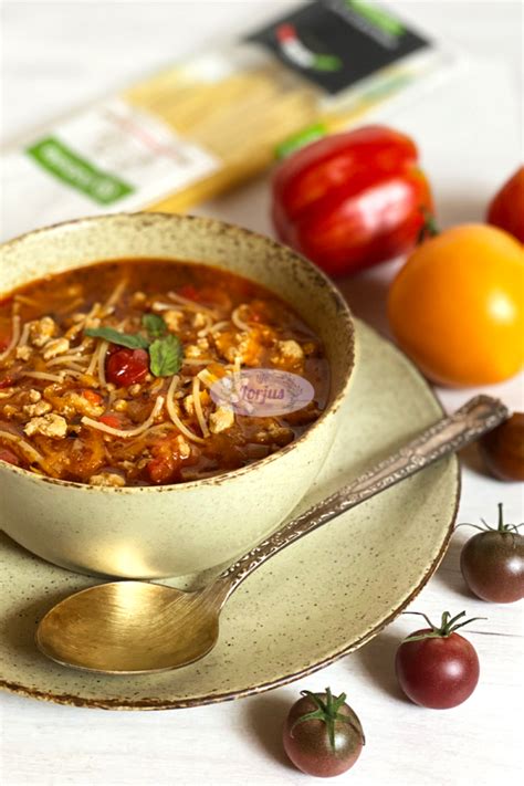 Lėkštė pomidorų sriubos su makaronais ir šviežiais žalumynais