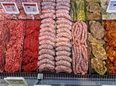 Pirkėjas renkasi šviežią mėsą parduotuvės vitrinoje
