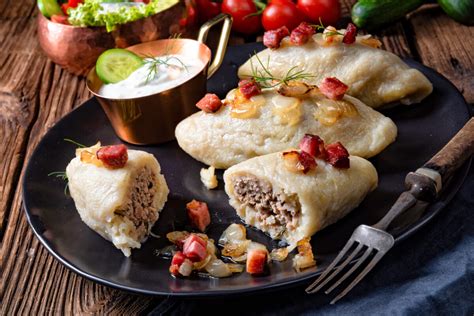 Nuotrauka su gražiai patiektu lėkštės cepelinų