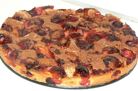 Gražiai paruoštas slyvų pyragas su marcipanais