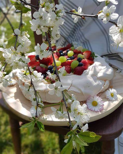 Šviežių uogų ir kremo sluoksniai ant Pavlova pagrindo