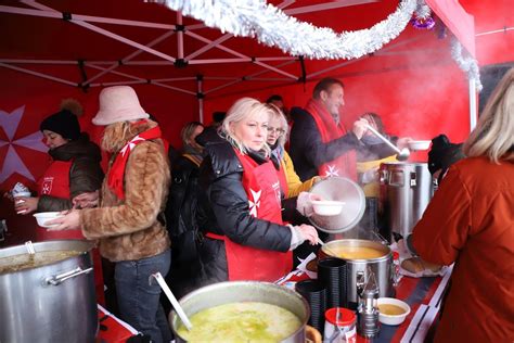 Maltiečių savanoriai dalinantys sriubą vienišam seneliui