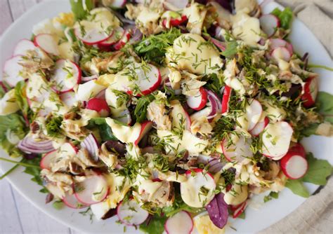Skumbrės salotos su įvairiais ingredientais lėkštėje