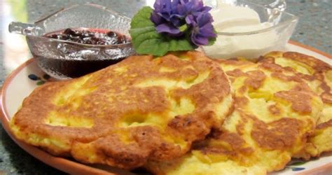 Nuotrauka, kurioje pavaizduoti paruošti varškės blyneliai su džiovintais ananasais.