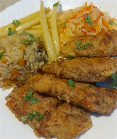 Afrikietiškas Jollof ryžių patiekalas su kepta žuvimi ir daržovėmis