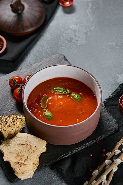Lėkštė trintos pomidorų sriubos su šviežiais baziliko lapeliais