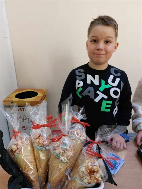 Žmonės aukojantys į labdaros dėžutę prie pyragų