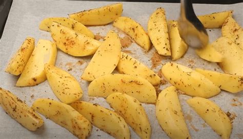 Nuotrauka bulvių griežinėlių, išdėliotų ant kepimo skardos