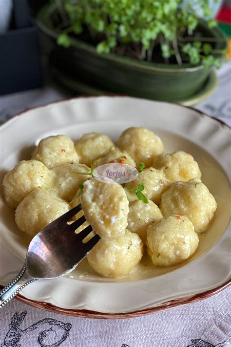 Lietuviškų bulvių kukuliai ant lėkštės su grietine ir spirgučiais