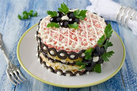 sluoksniuotas krabų lazdelių tortas lėkštėje