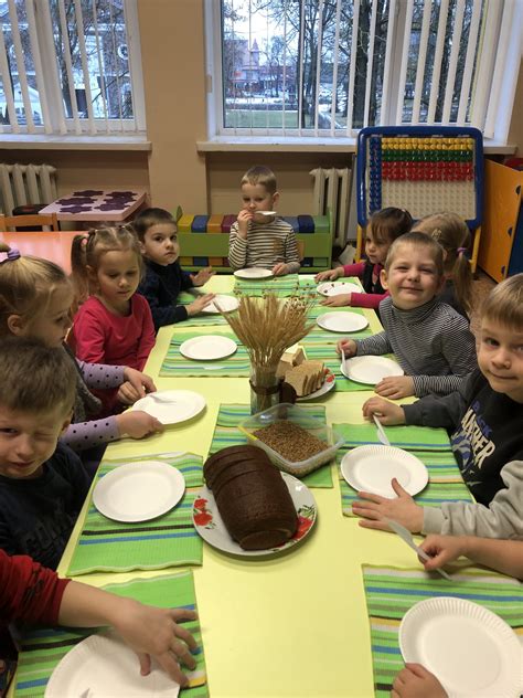 Vaikai rankomis laužia duonos riekę