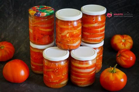 Konservuotų pomidorų skardinės ir švieži pomidorai