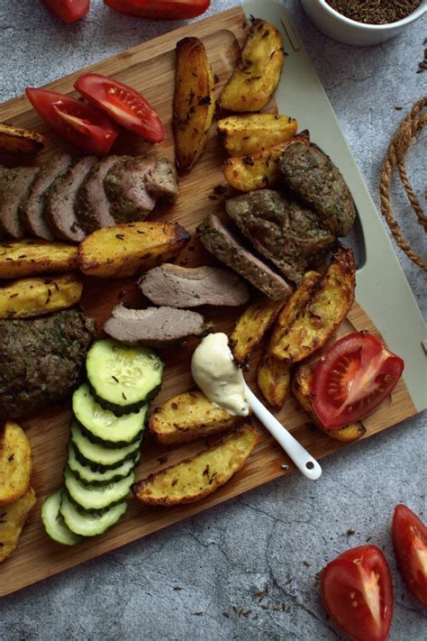 lėkštė su auksinėmis keptomis bulvių skiltelėmis