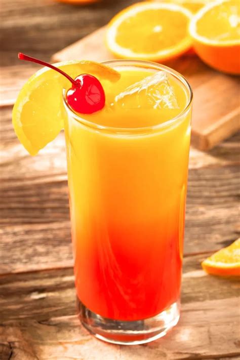 Tequila Sunrise kokteilis su apelsino griežinėliu ir vyšnia