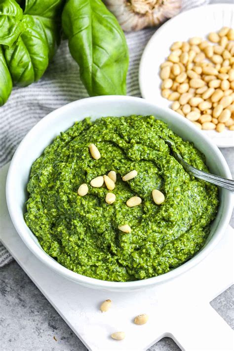 Šviežių bazilikų lapeliai, kedro riešutai ir alyvuogių aliejus tradicinio pesto ingredientai