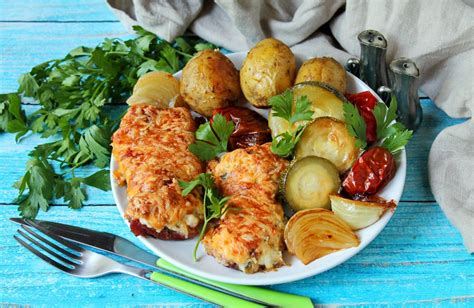 Grilinė su kepančia kiauliena, aplinkui daržovės ir prieskoniai